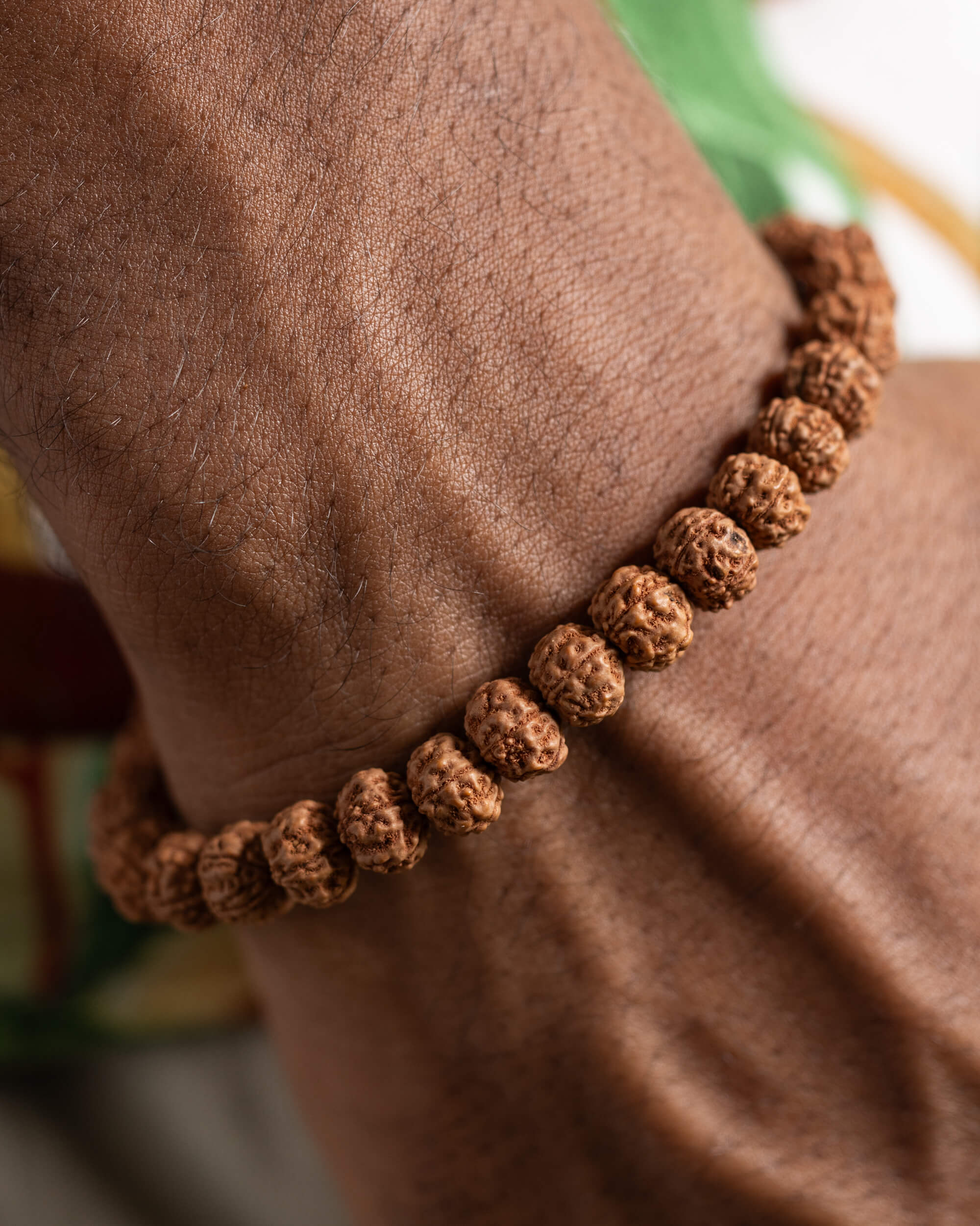 Pulsera de Semillas de Rudraksha puesta en la muñeca, detalle cercano de las semillas