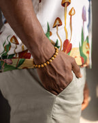 Pulsera de Jaspe Madera puesta en la muñeca, con camisa estampada de hongos