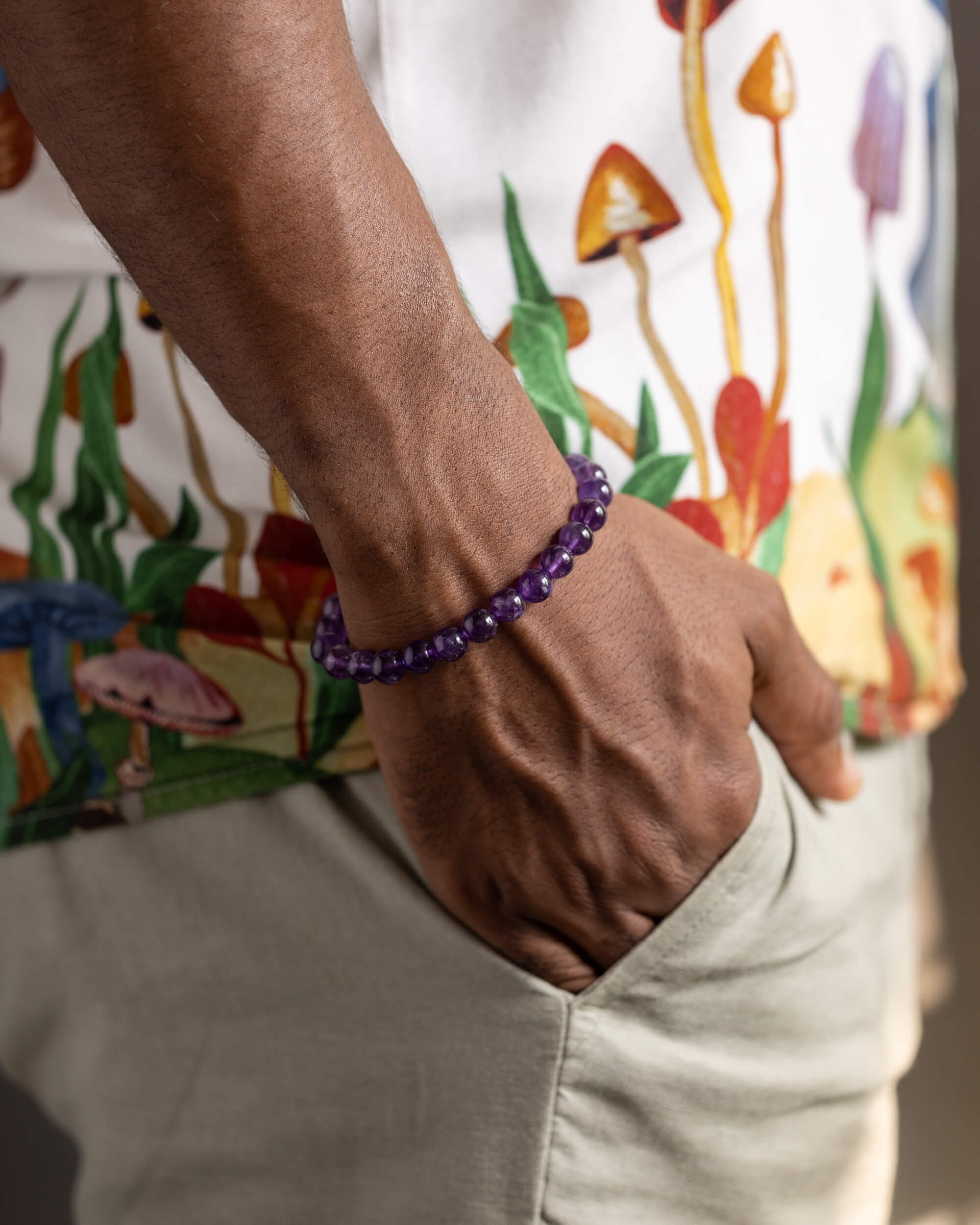 Pulsera de Amatista puesta en la muñeca, con la mano en el bolsillo
