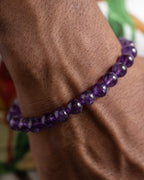 Pulsera de Amatista puesta en la muñeca, entre follaje verde