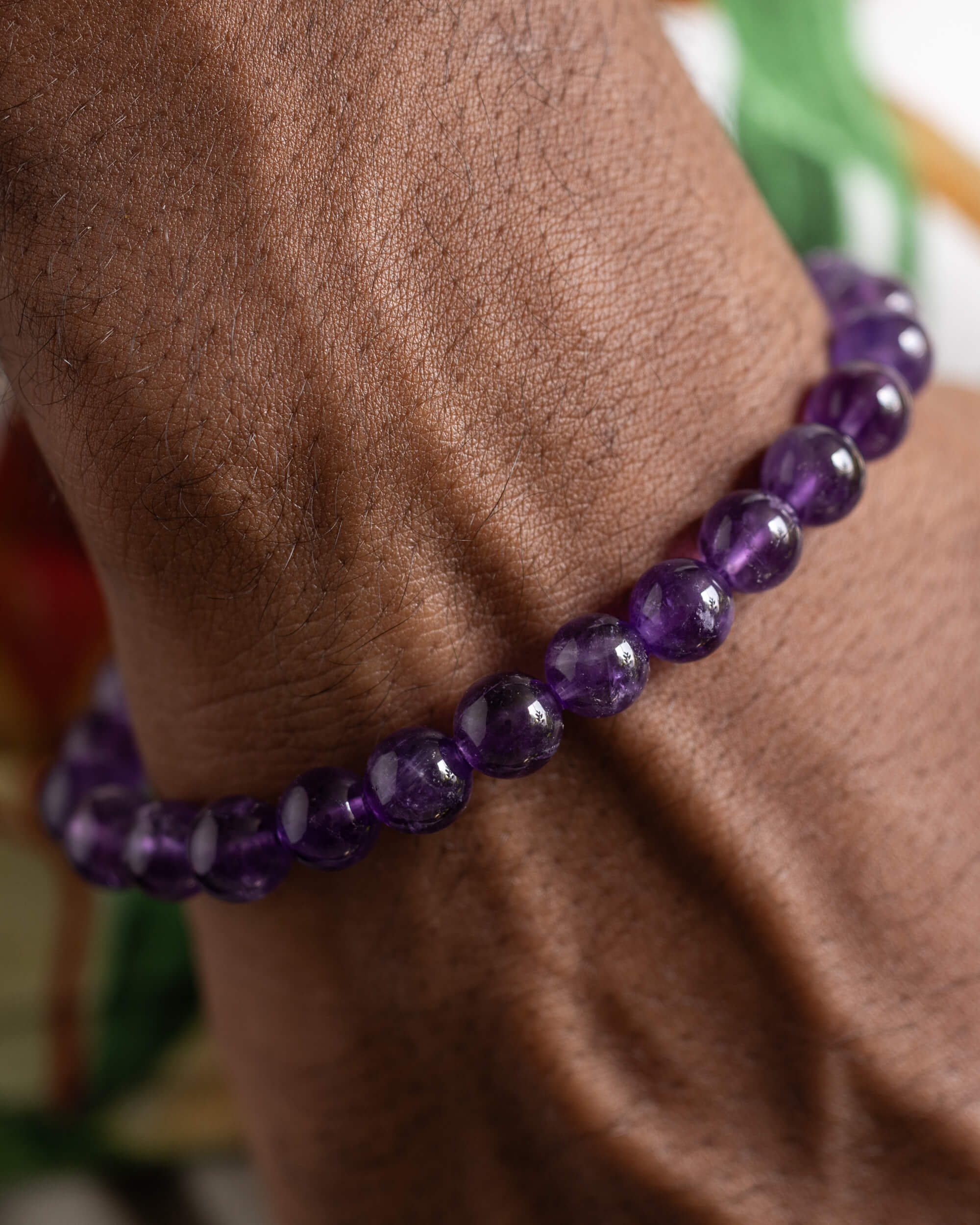 Pulsera de Amatista puesta en la muñeca, entre follaje verde