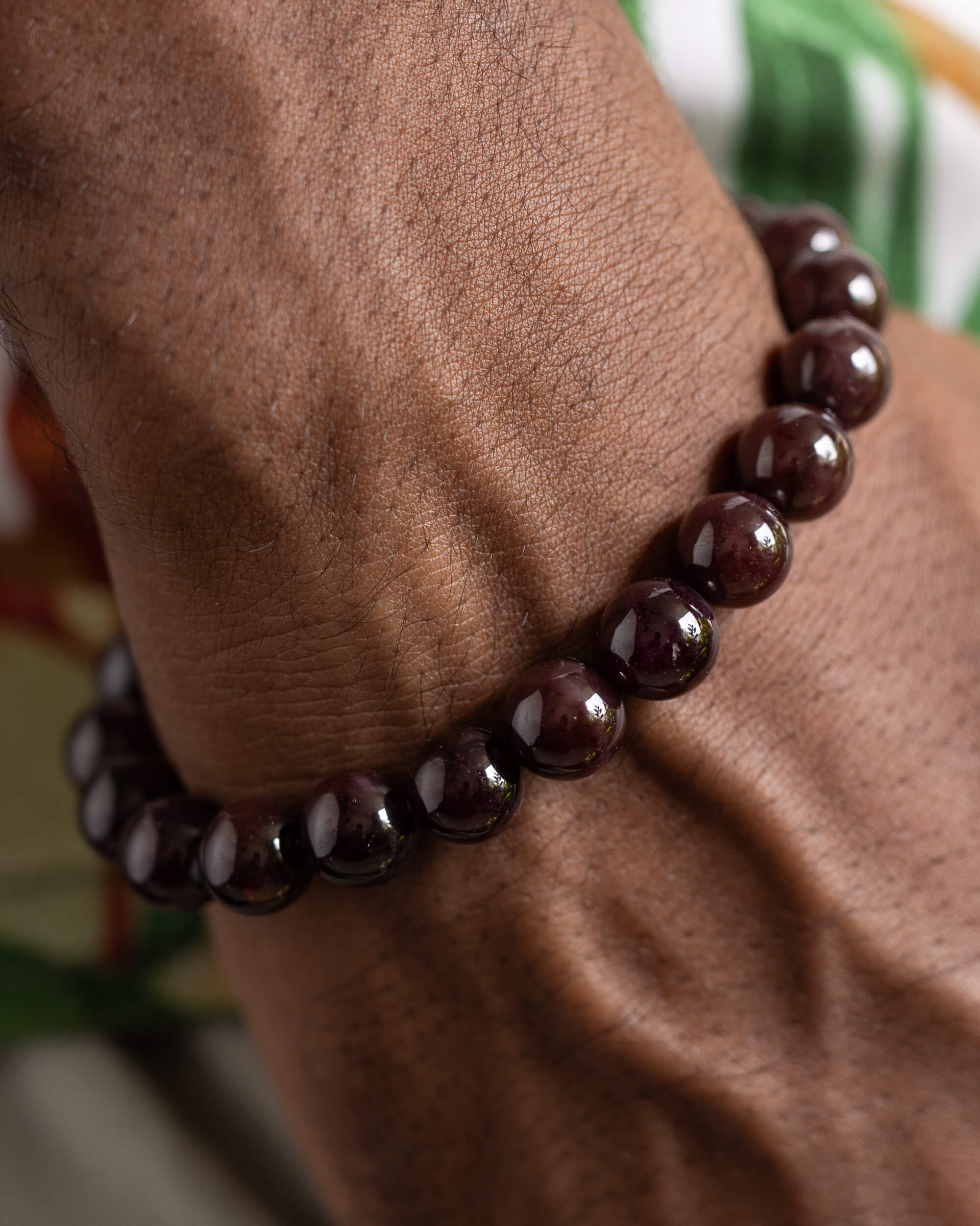 Pulsera de Granate Estrella puesta en la muñeca, vista cercana del brazo