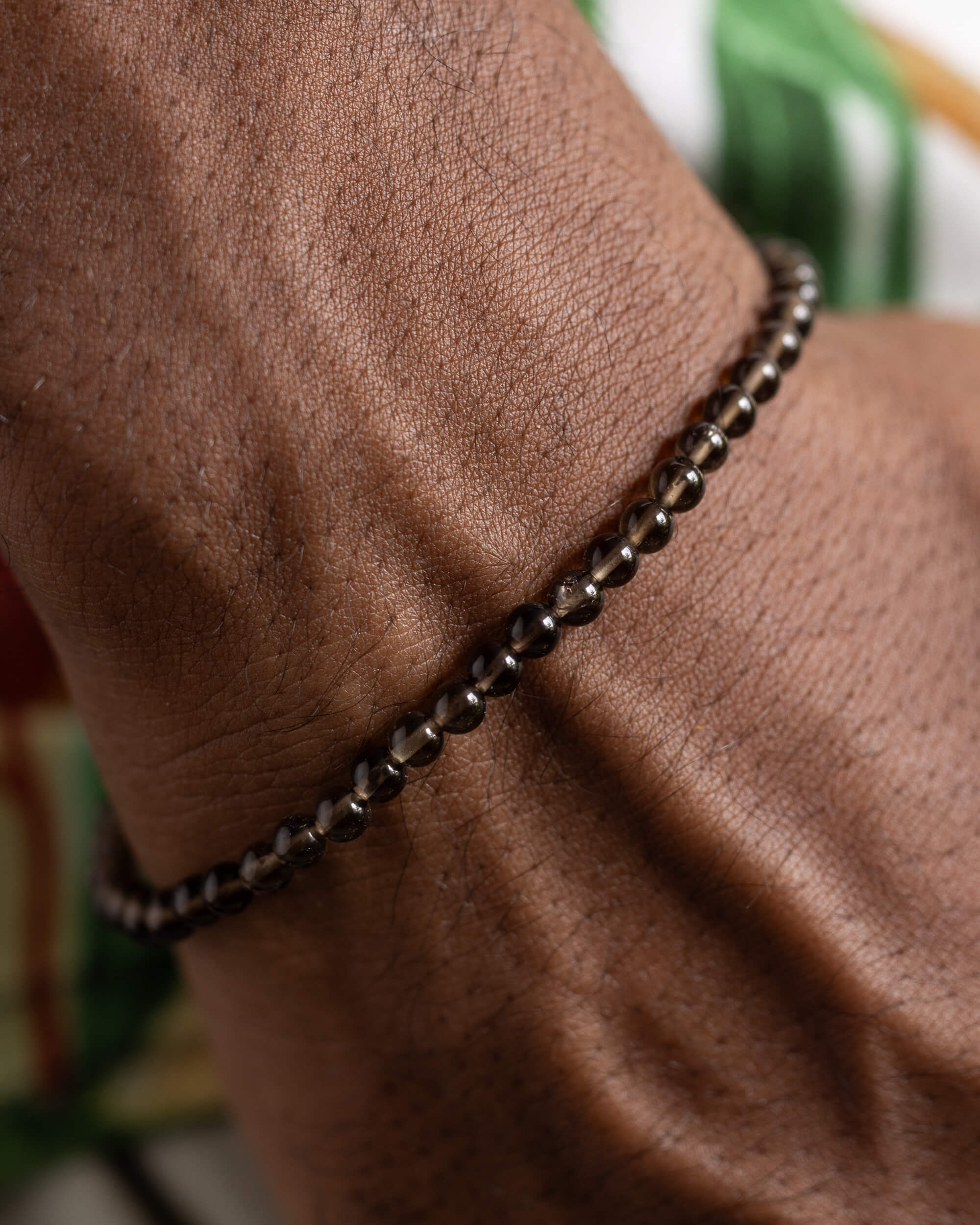 Pulsera de Cuarzo Ahumado puesta, acercamiento a las cuentas sobre la muñeca