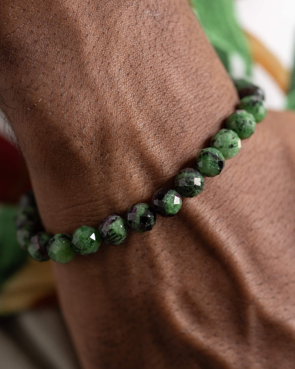 Pulsera de Zoisita puesta en la muñeca, detalle cercano de las cuentas verdes