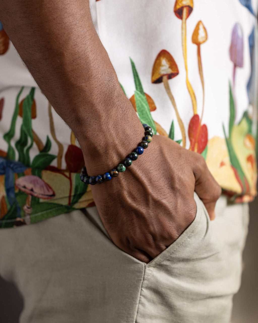 Pulsera de Crisocola puesta en la muñeca, con camisa estampada de hongos