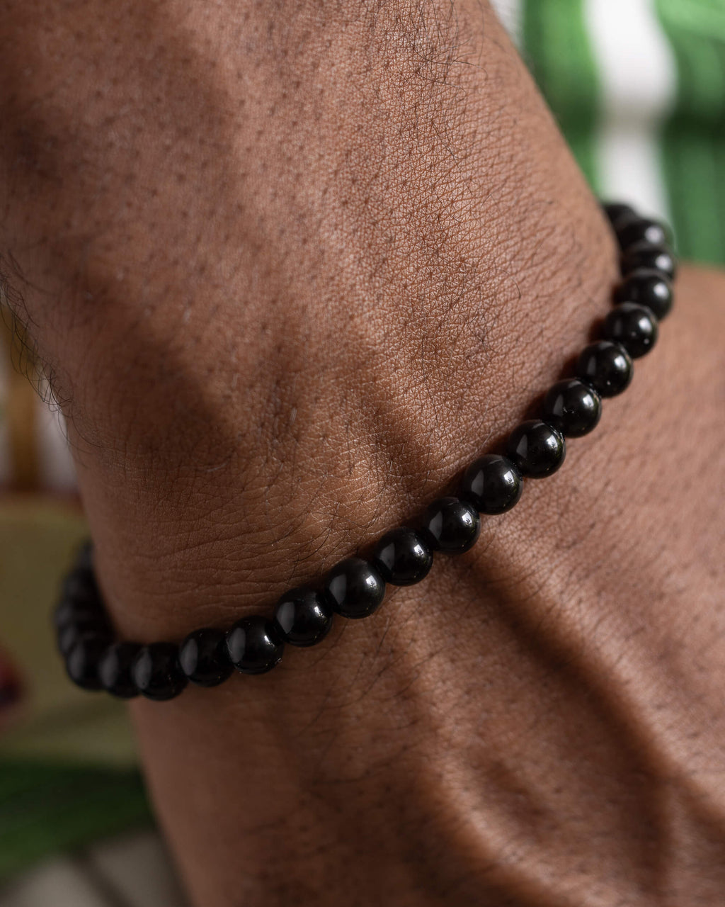 Pulsera de Obsidiana Arcoíris puesta, acercamiento a la muñeca en reposo
