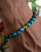 Pulsera Tamanuiterā puesta en la muñeca, cuentas de Apatita Azul y Ámbar visibles