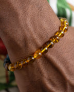 Pulsera Tamanuiterā puesta en la muñeca, cuentas de Ámbar cerca de la mano