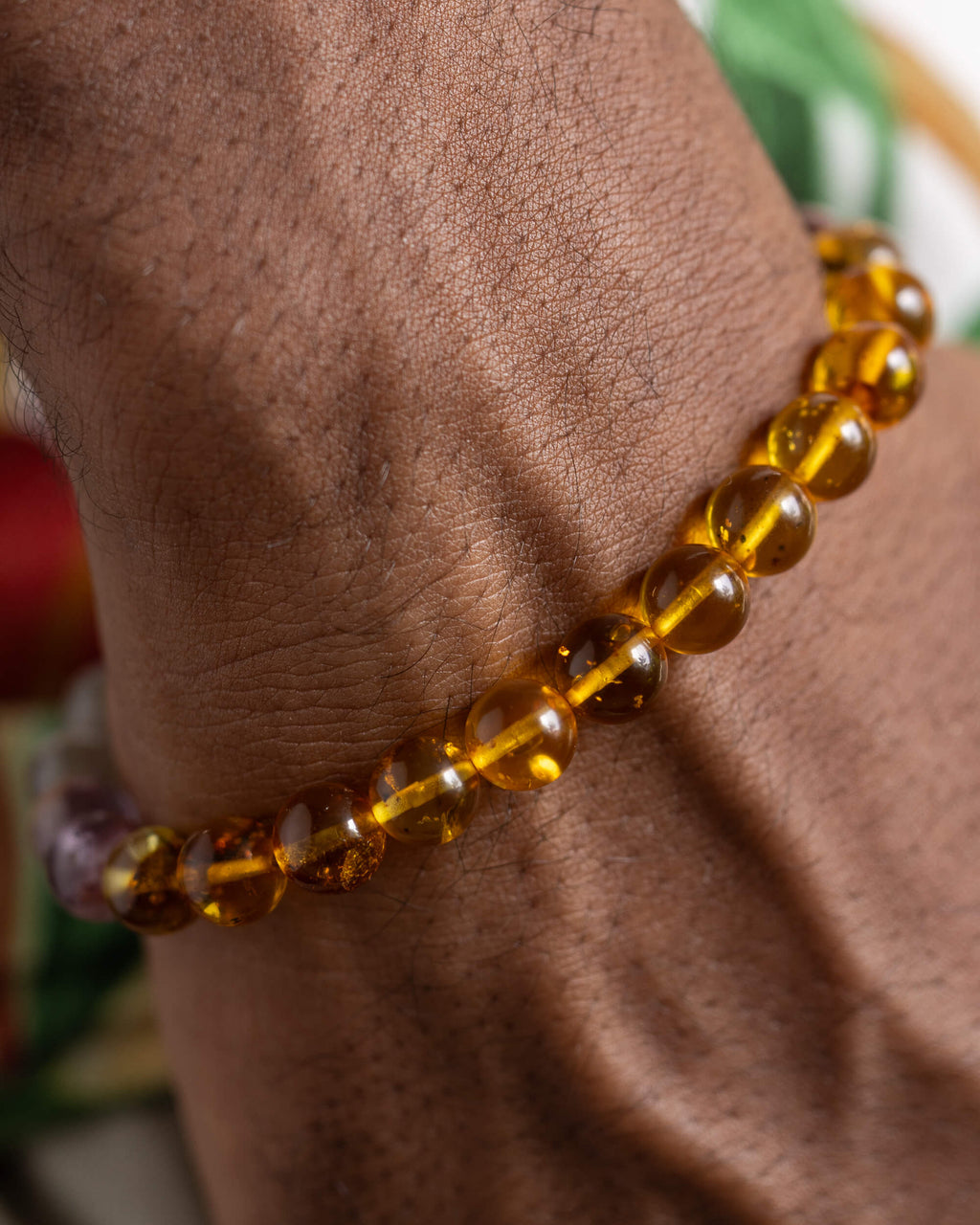 Pulsera Mithra puesta en la muñeca, cuentas de Ámbar cerca de la mano