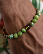 Pulsera Usil puesta en la muñeca, cuentas de Jade Verde y Ámbar visibles