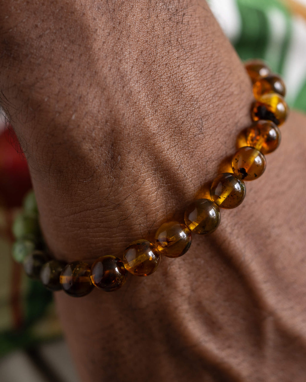 Pulsera Usil puesta en la muñeca, cuentas de Ámbar cerca de la mano