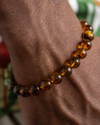 Pulsera Usil puesta en la muñeca, cuentas de Ámbar cerca de la mano