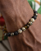 Pulsera Malakbel puesta en la muñeca, detalle cercano de Piedra Volcánica y Pirita