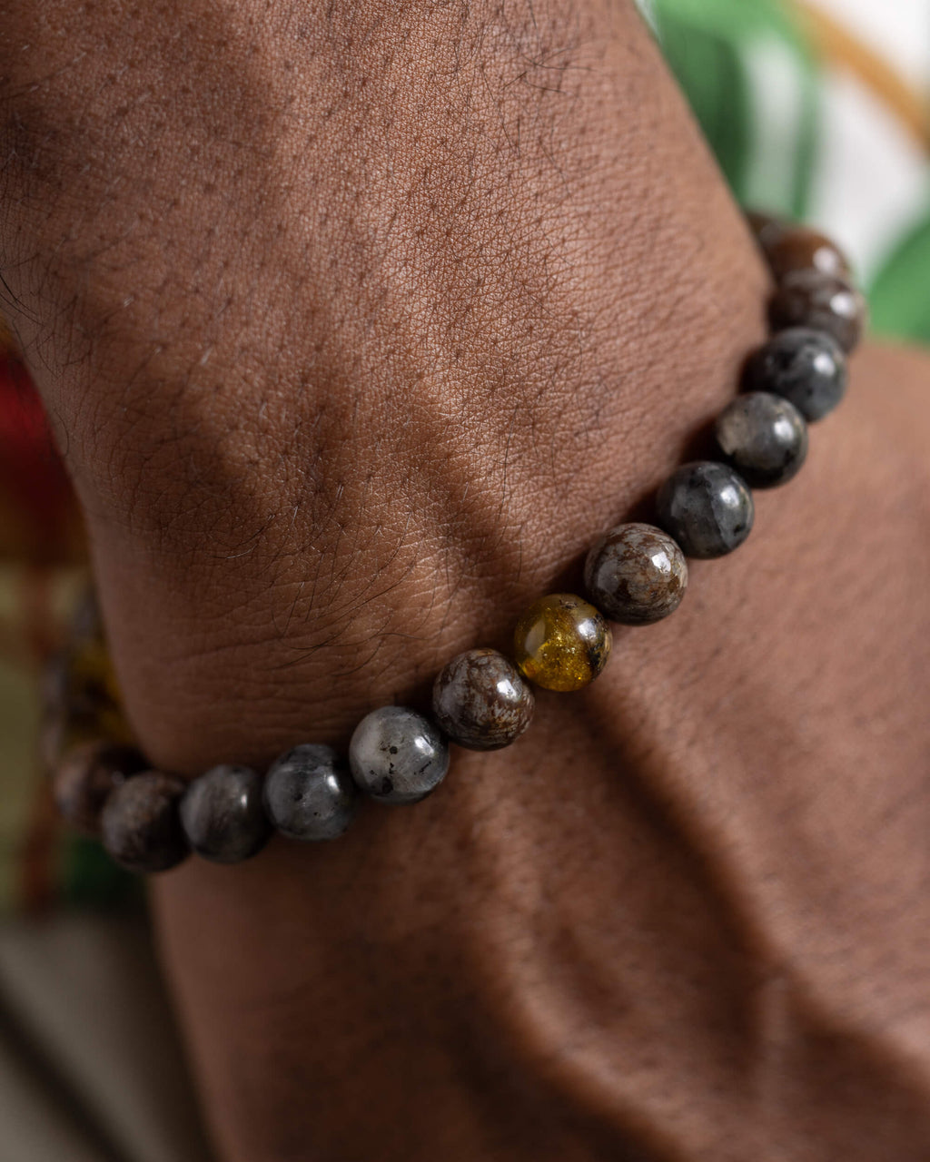 Pulsera Yhi puesta en la muñeca, combinacion de Larvikita y Ámbar visible