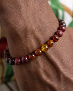 Pulsera Inti puesta en la muñeca, detalle cercano del tramo de granate y Ámbar