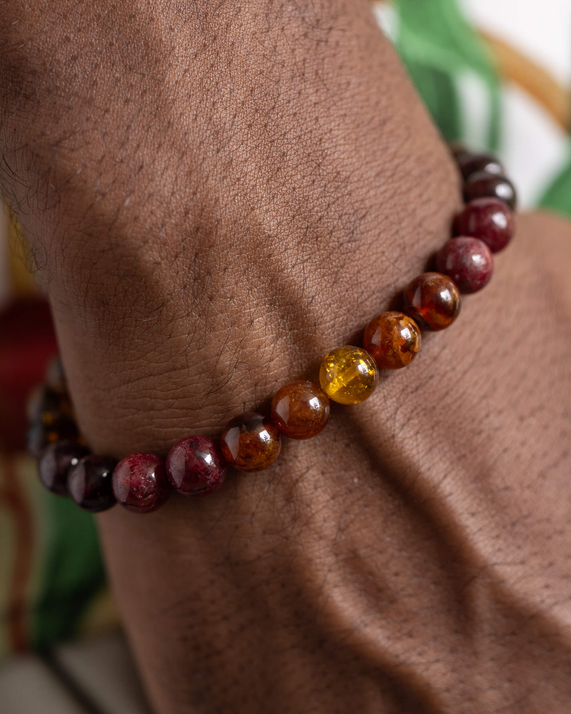 Pulsera Inti puesta en la muñeca, detalle cercano del tramo de granate y Ámbar
