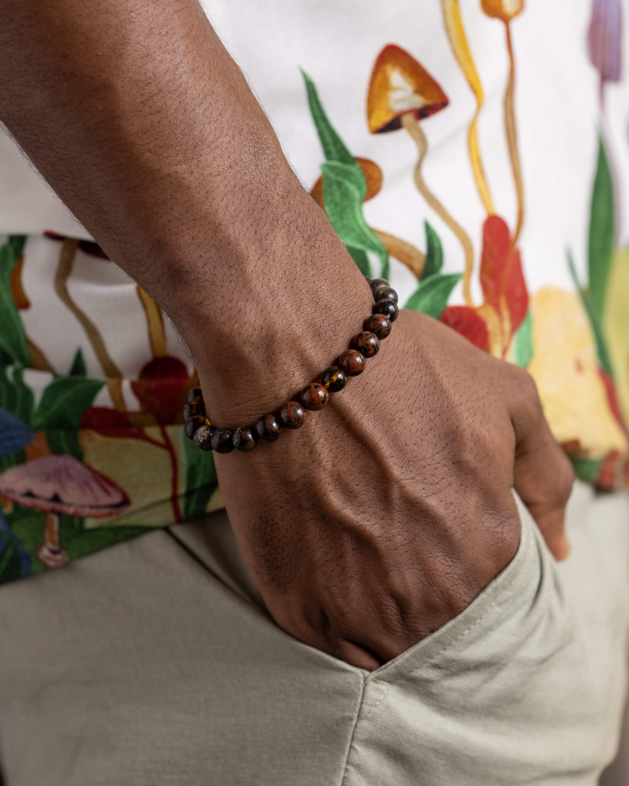 Pulsera Kinich Ahau puesta en la muñeca, con la mano en el bolsillo