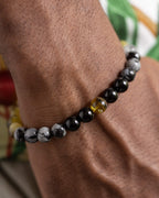 Pulsera Horus puesta en la muñeca, combinacion de minerales oscuros y Ámbar