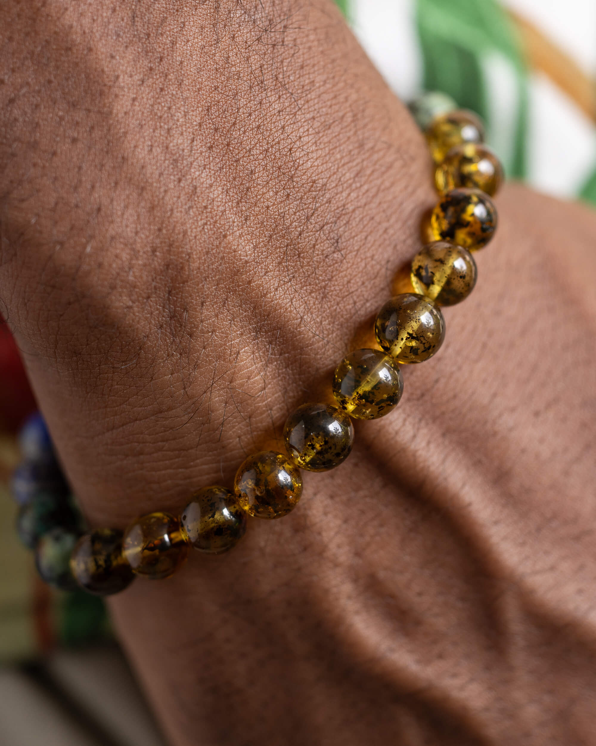 Pulsera Utu puesta en la muñeca, cuentas de Ámbar en primer plano