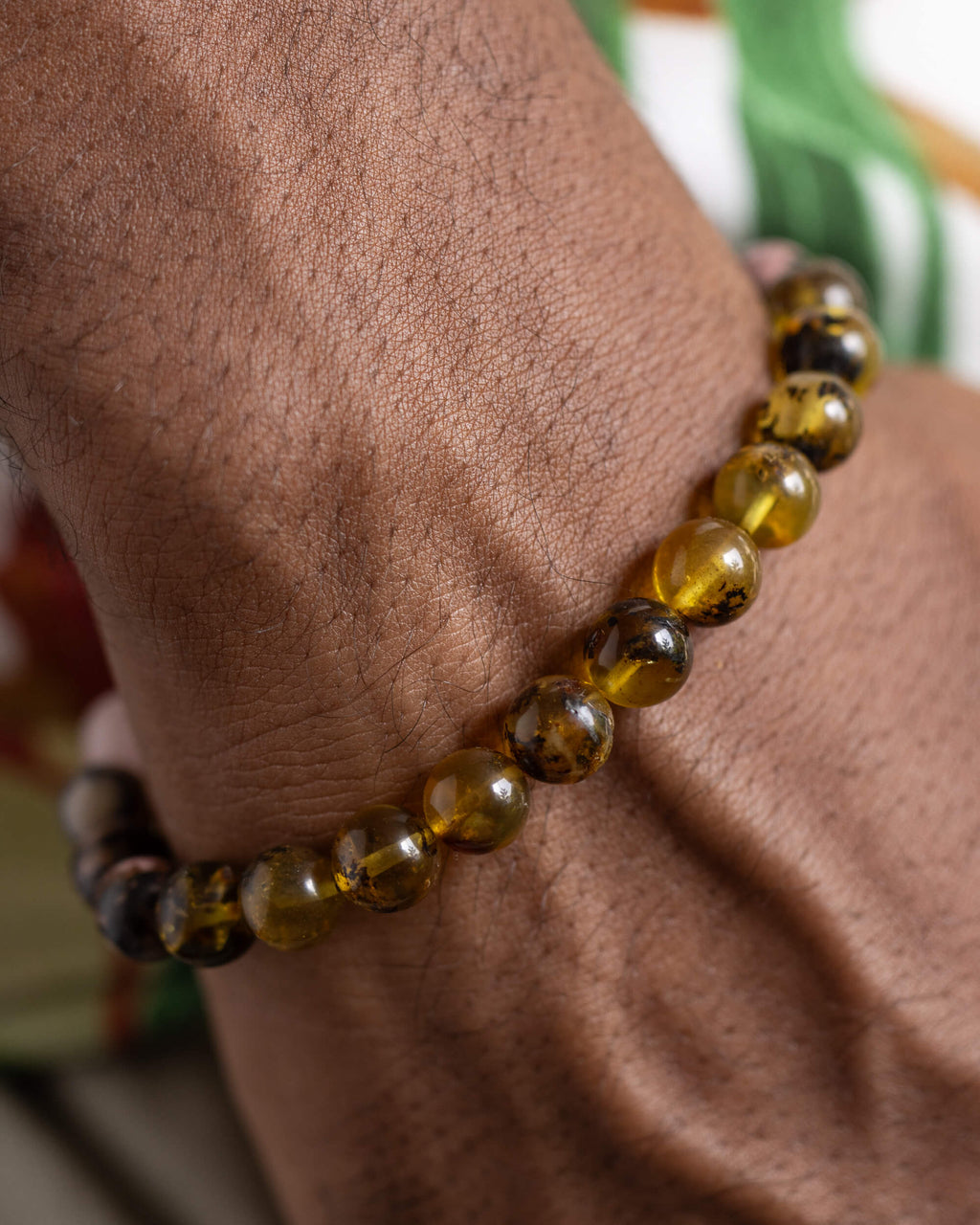 Pulsera Saule puesta en la muñeca, cuentas de Ámbar cerca de la mano