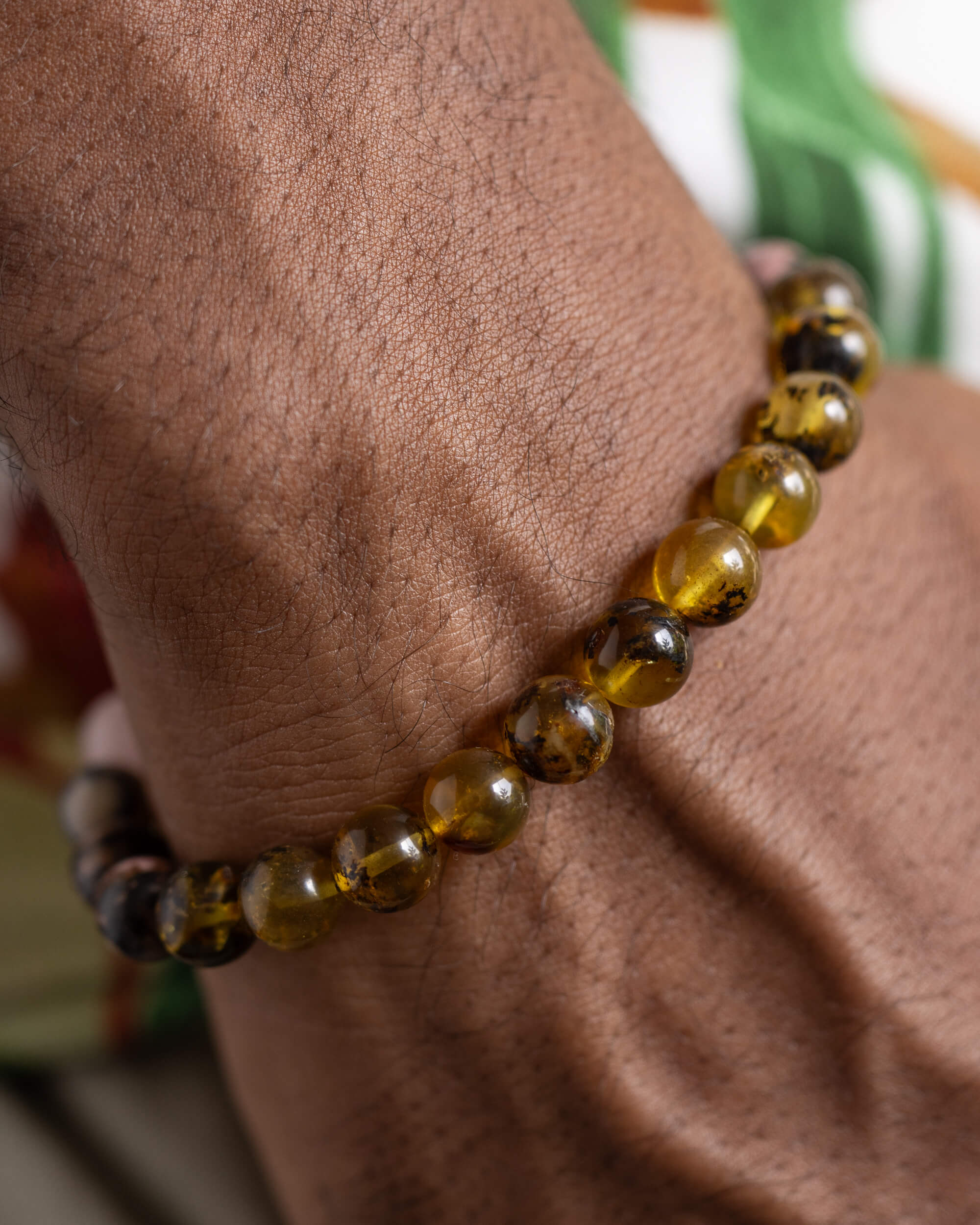 Pulsera Saule puesta en la muñeca, cuentas de Ámbar cerca de la mano