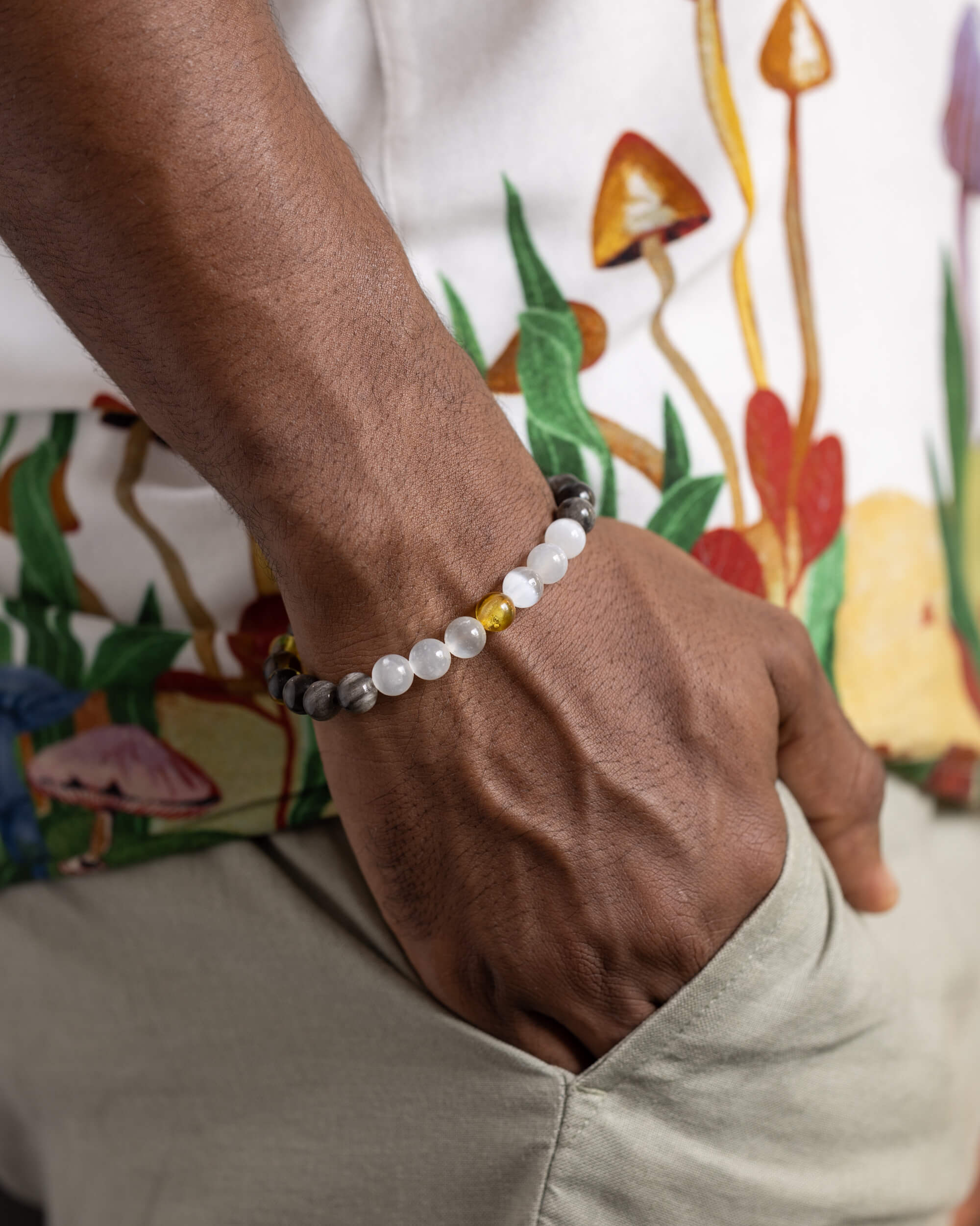 Pulsera Amaterasu puesta en la muñeca, con cuentas de Selenita, Obsidiana y Ámbar
