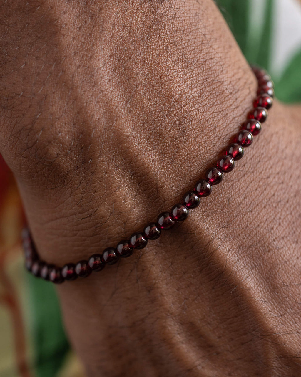 Pulsera de Granate Rojo puesta en la muñeca, vista cercana del brazo doblado