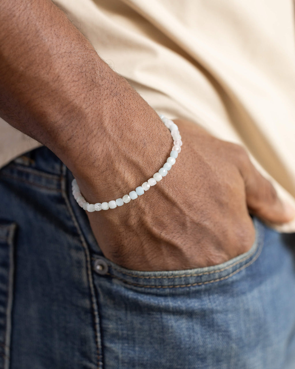Pulsera de Morganita y Aguamarina puesta en la muñeca, con la mano en el bolsillo del pantalón
