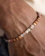 Pulsera de Rodonita puesta en la muñeca, cuentas claras y doradas visibles