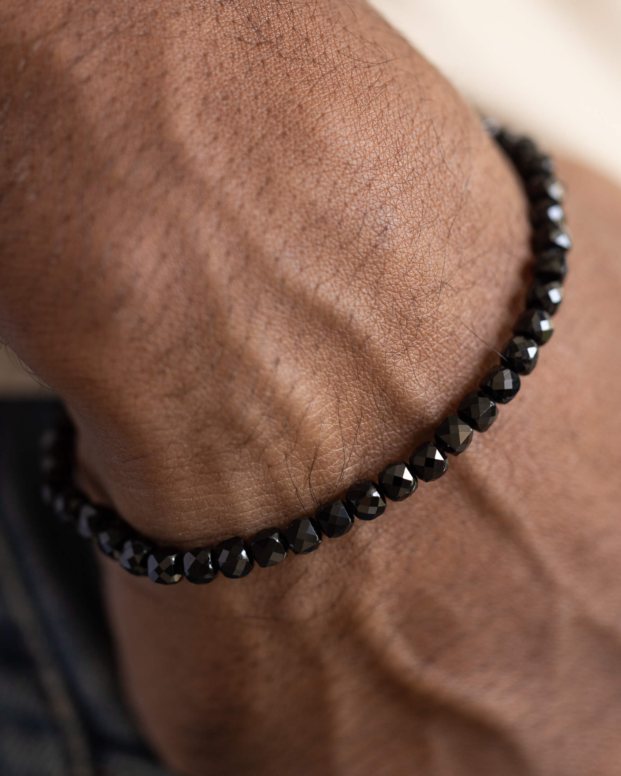 Pulsera de Espinela Negra puesta, detalle cercano de la muñeca