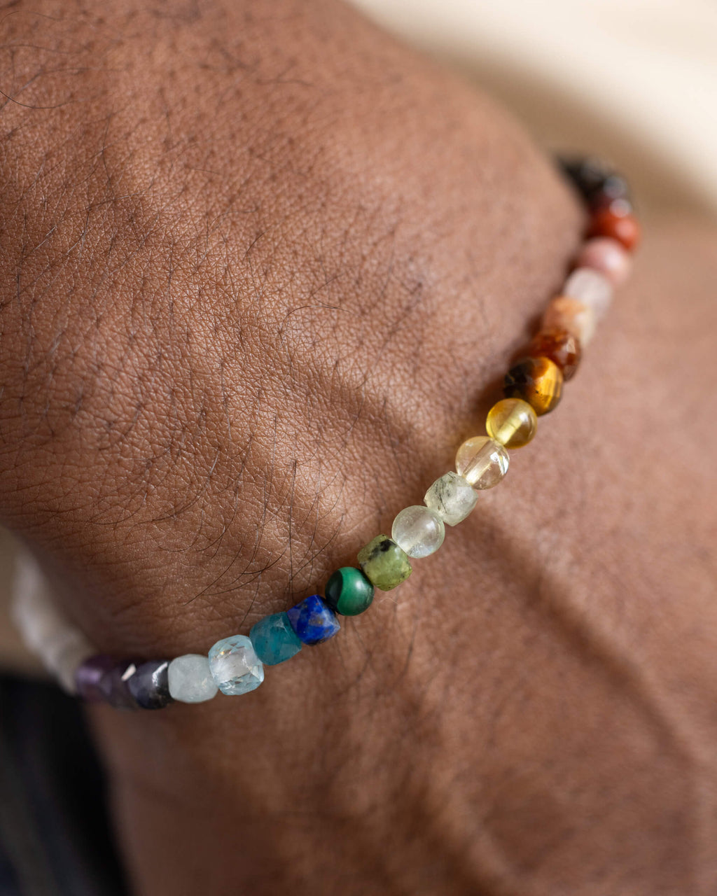 Pulsera Unidad puesta en la muñeca, mostrando el degradado completo de sus 23 minerales