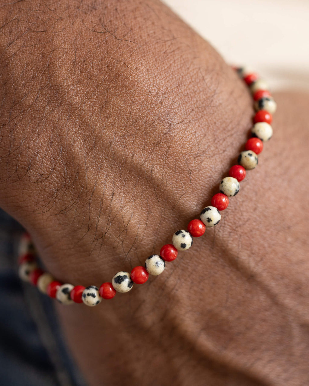 Pulsera de Jaspe Dálmata y Coral Rojo puesta en la muñeca