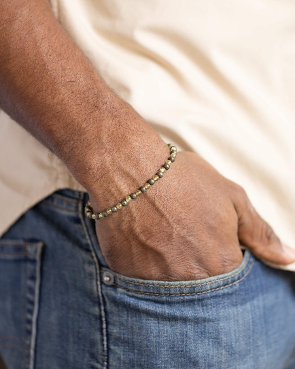Pulsera de Cuarzo Rutilado y Pirita puesta, mano dentro del bolsillo