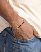 Pulsera de Cuarzo Rutilado y Pirita puesta, mano dentro del bolsillo