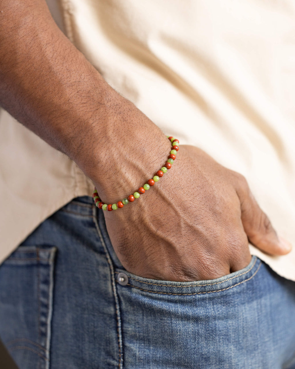 Pulsera de Jaspe Rojo y Jade Verde puesta, la mano en el bolsillo