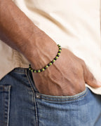 Pulsera de Turmalina Negra y Jade Verde puesta, la mano en el bolsillo