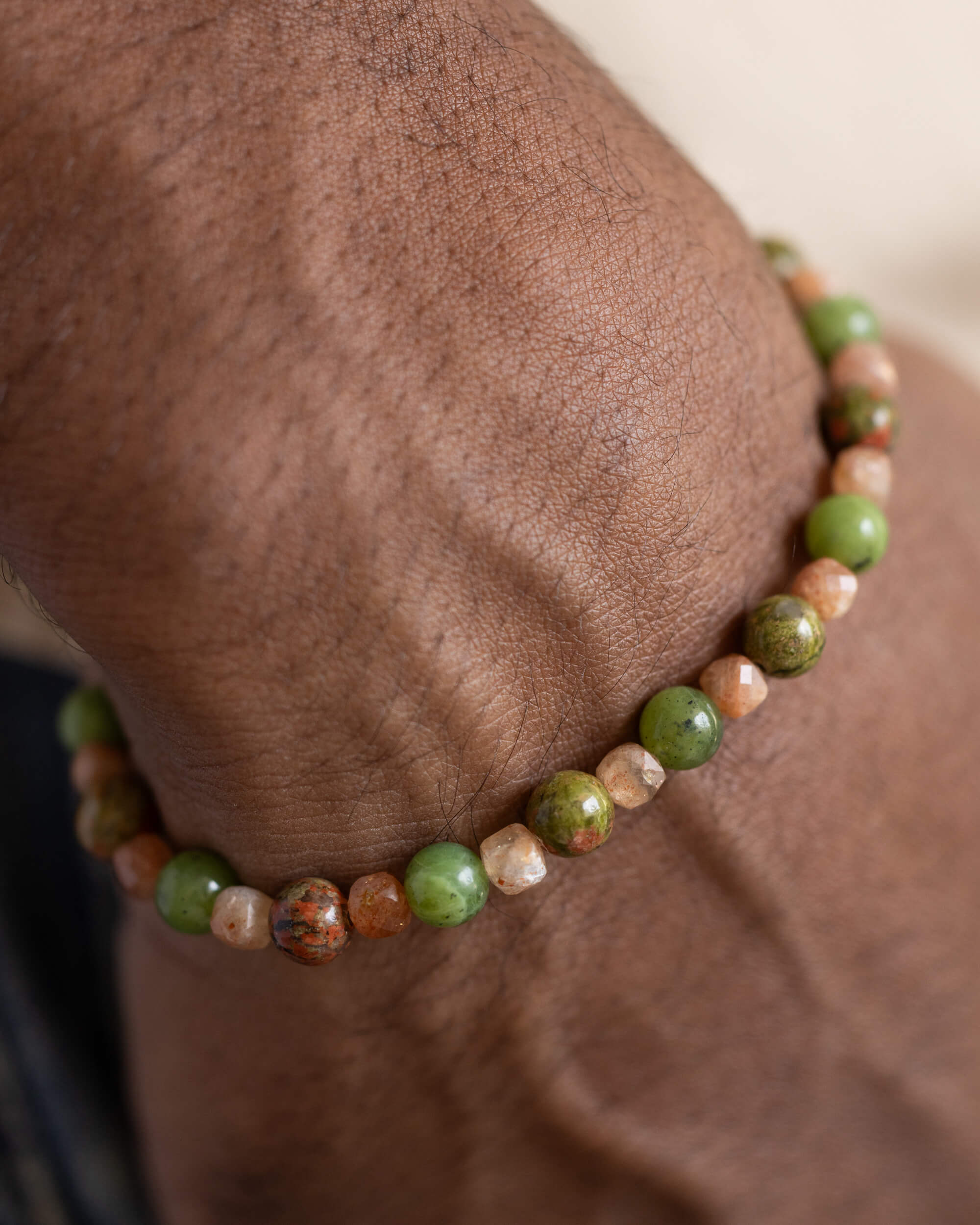 Pulsera de Jade Verde, Jaspe Unakita y Piedra Sol puesta en la muñeca