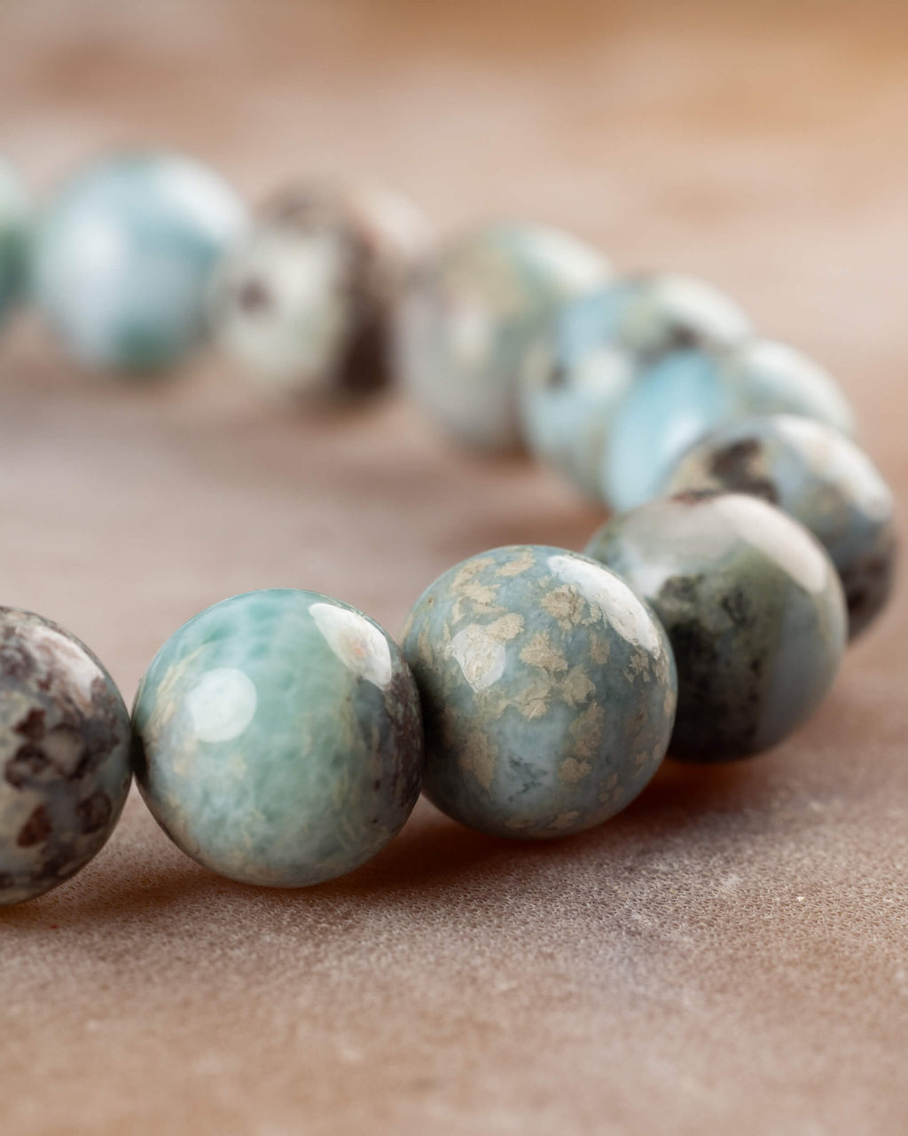 Pulsera de Larimar en curva, cuentas azules y grises sobre superficie clara