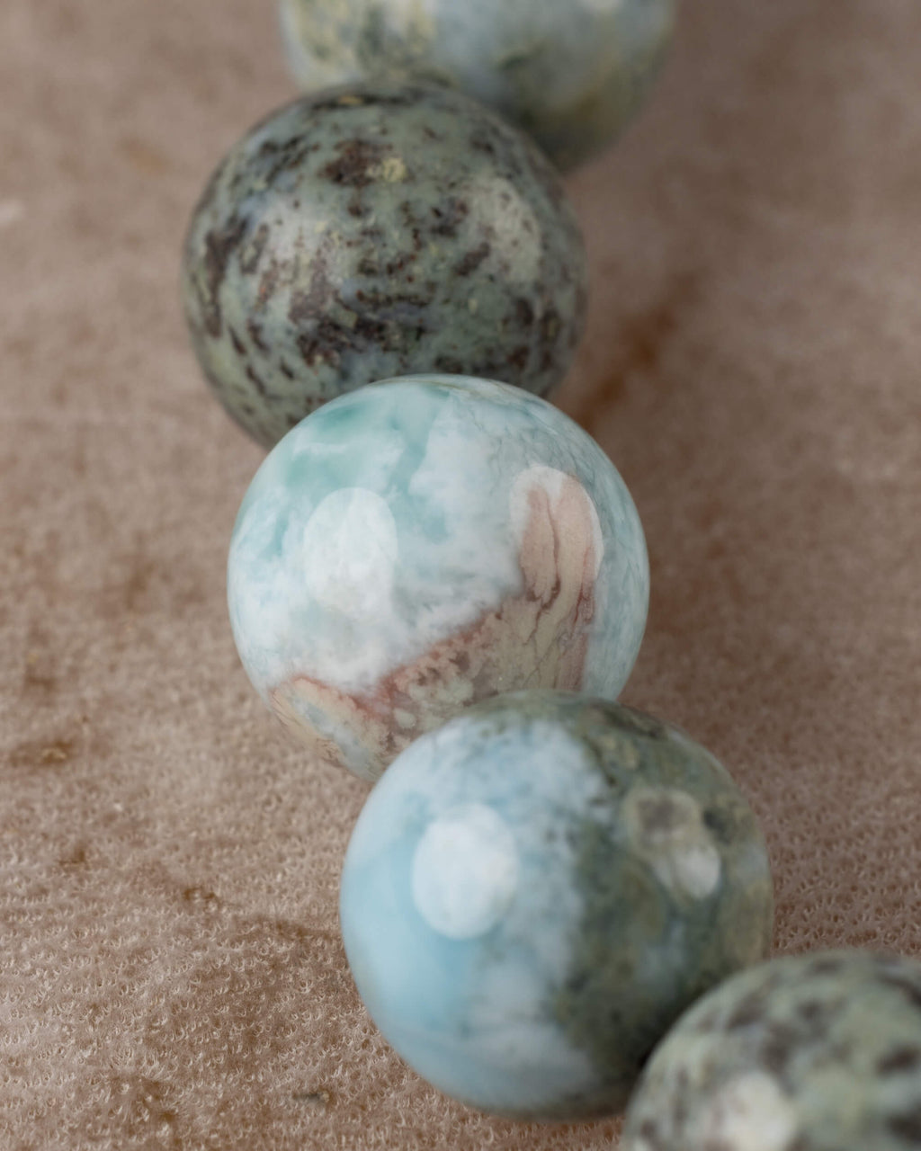 Detalle macro de las cuentas de Larimar en tonos azul claro y gris moteado