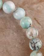 Detalle macro de las cuentas de Larimar con vetas cafes y azules