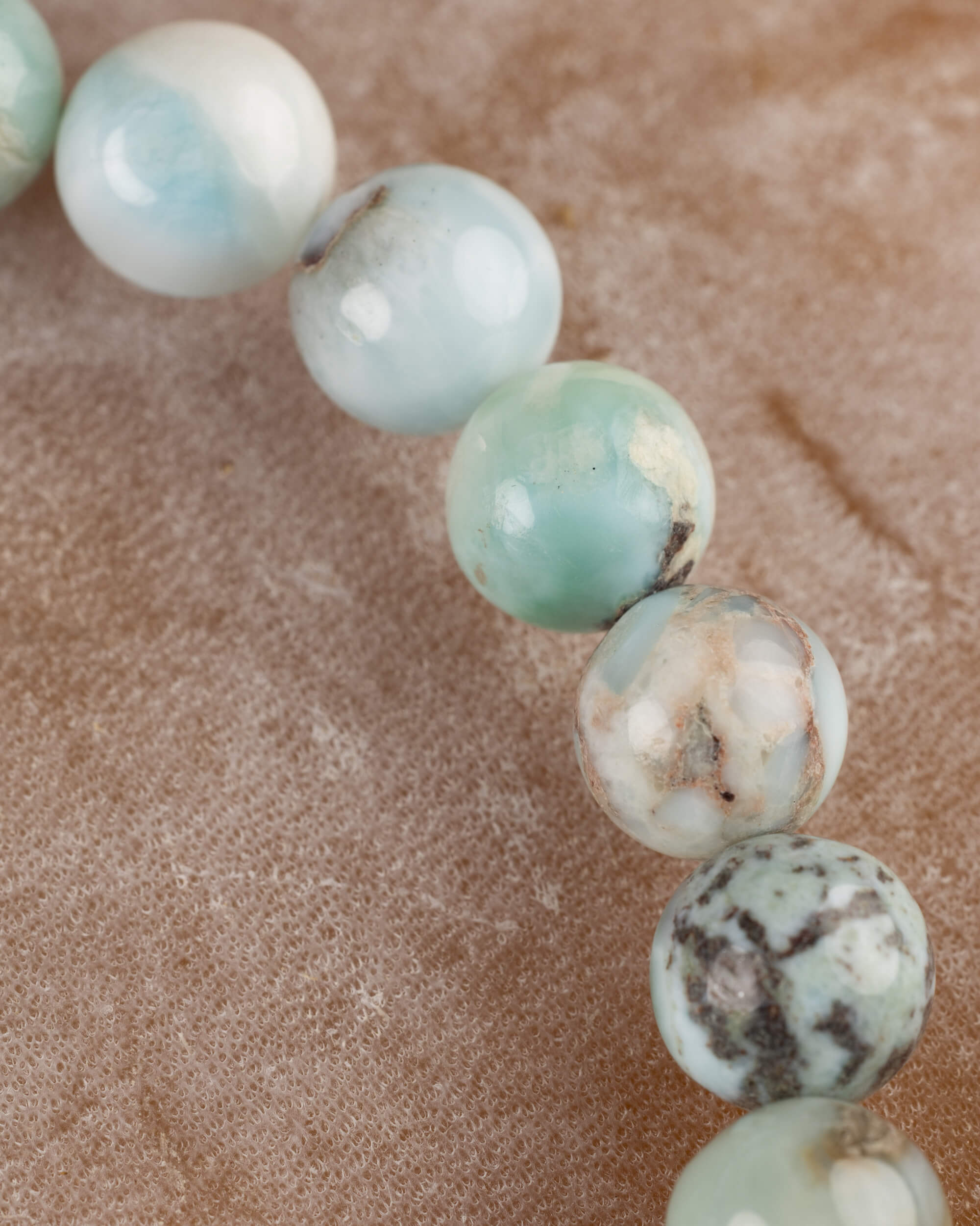 Detalle macro de las cuentas de Larimar con vetas cafes y azules