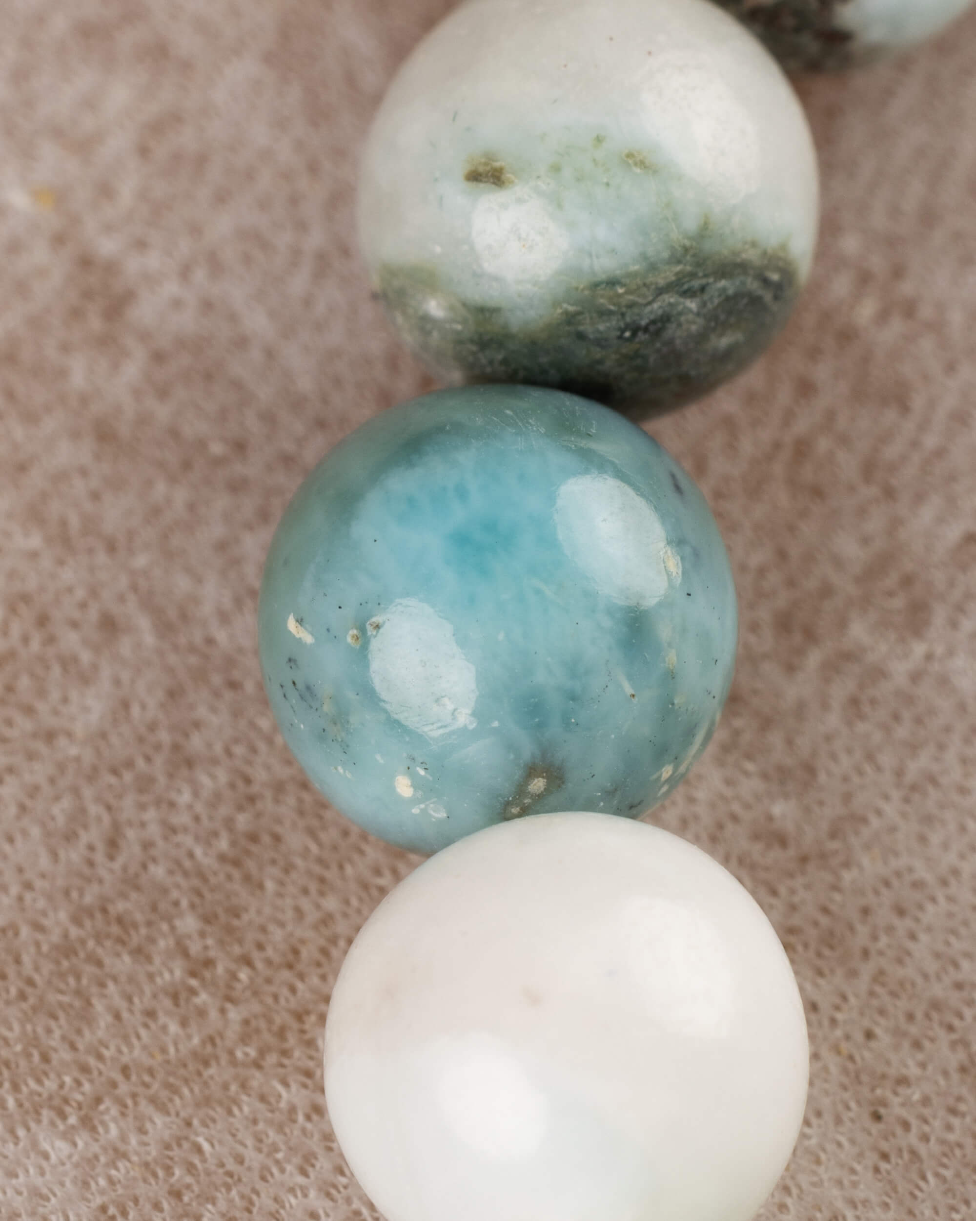 Detalle macro de las cuentas de Larimar en tonos azul y blanco