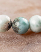Detalle macro de tres cuentas de Larimar con veta azul central