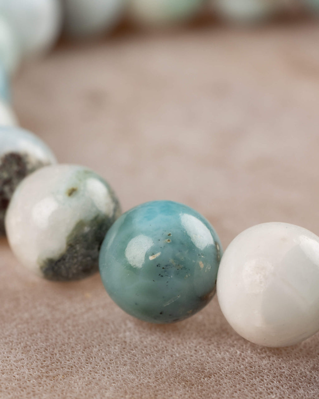 Detalle macro de las cuentas de Larimar con veta azul y blanca