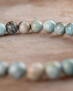 Pulsera de Larimar en angulo curvo, cuentas azules y beige