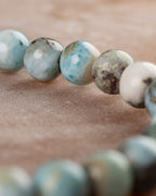 Pulsera de Larimar en curva, contraste de cuentas azules y blancas