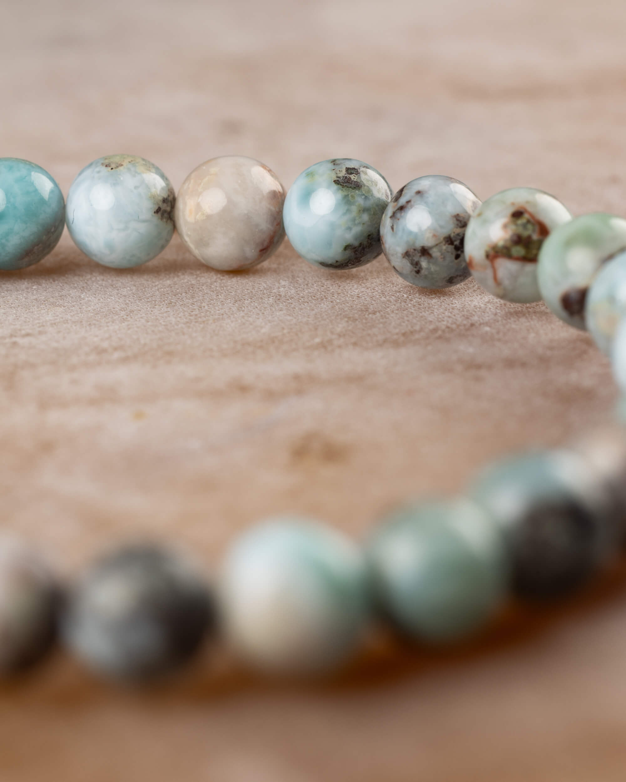 Pulsera de Larimar en curva, cuentas azul, beige y verde de cerca