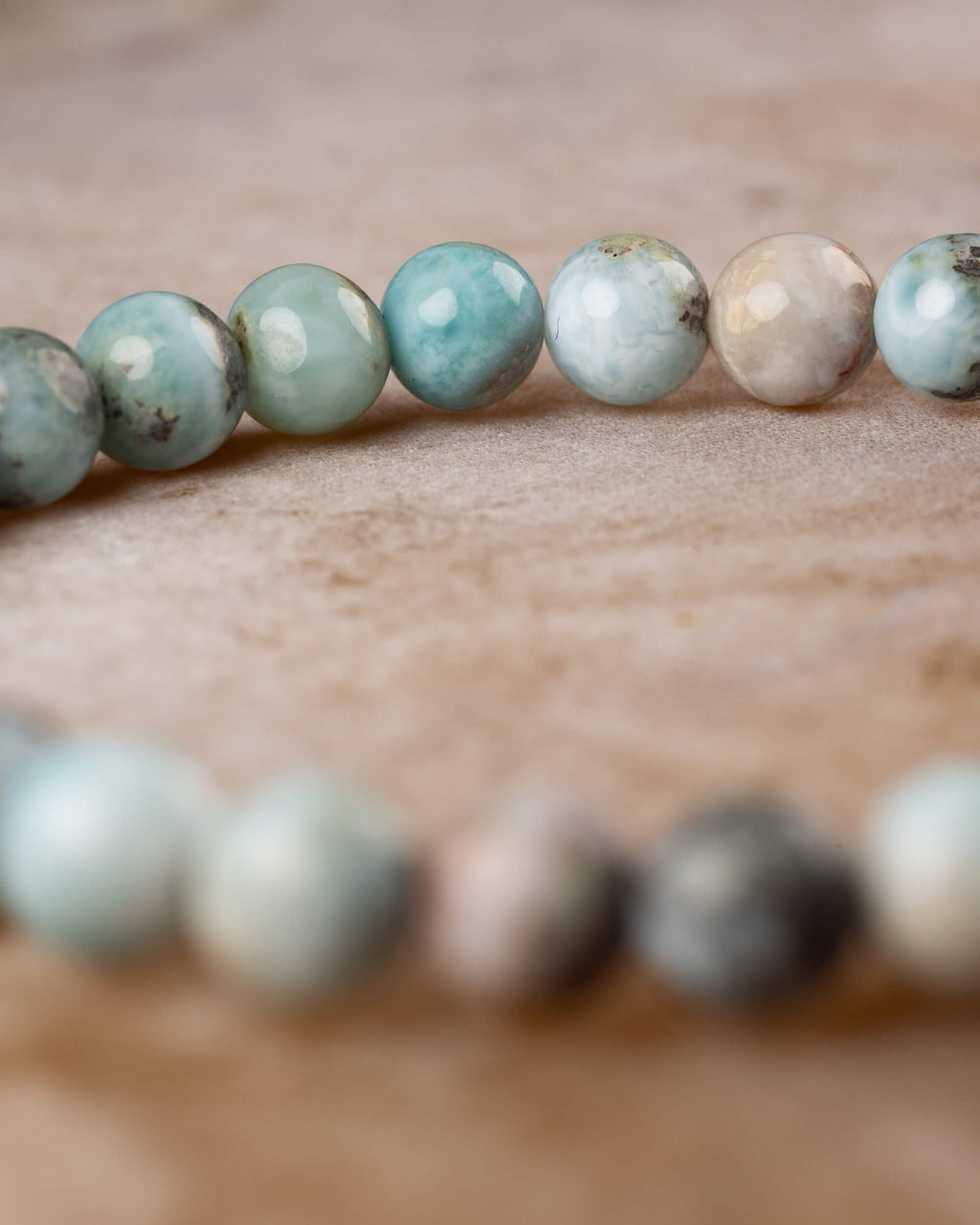 Pulsera de Larimar en angulo curvo, cuentas azules y beige en hilera