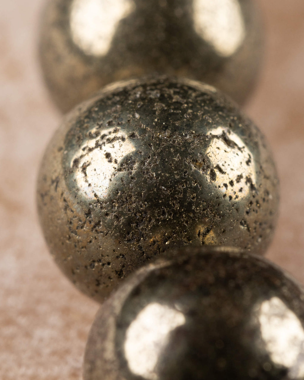 Detalle macro de las cuentas de Pirita, textura metalica y brillo dorado
