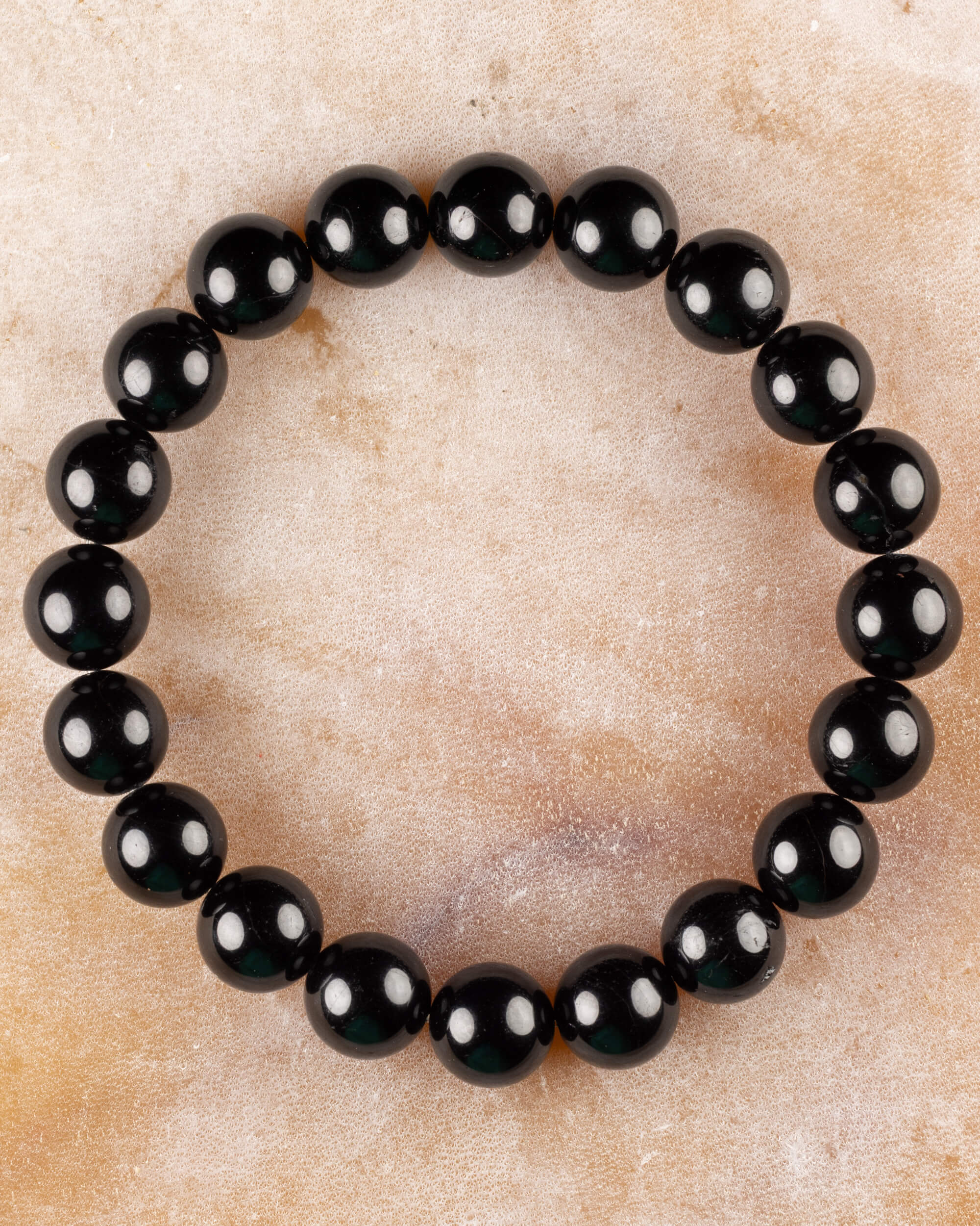 Pulsera de Turmalina Negra de 10 mm, pieza completa sobre superficie de mármol